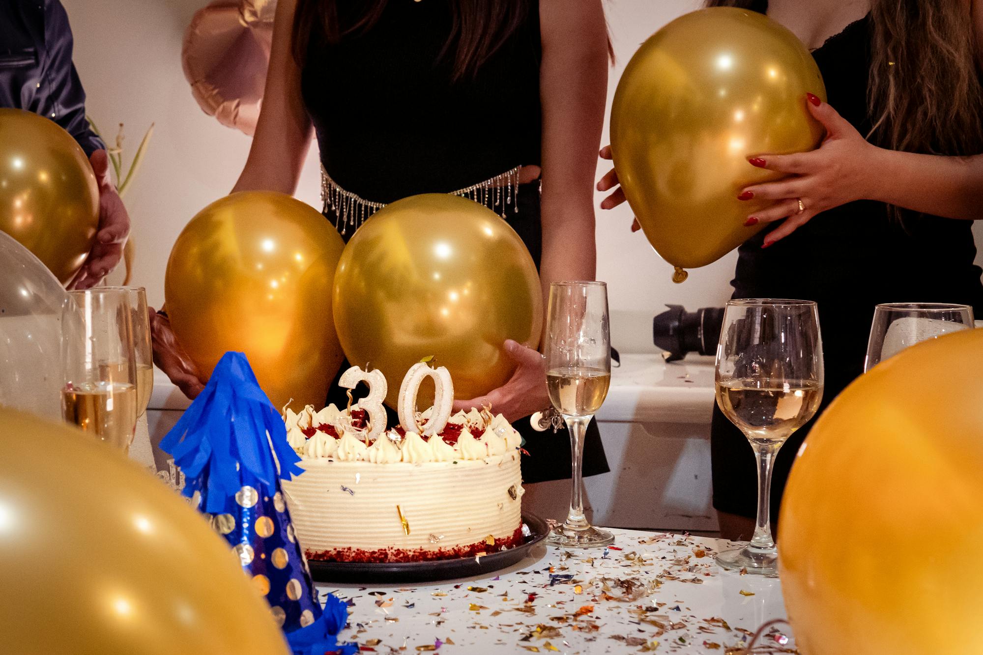 Elegant 30th birthday celebration with gold balloons, cake and champagne