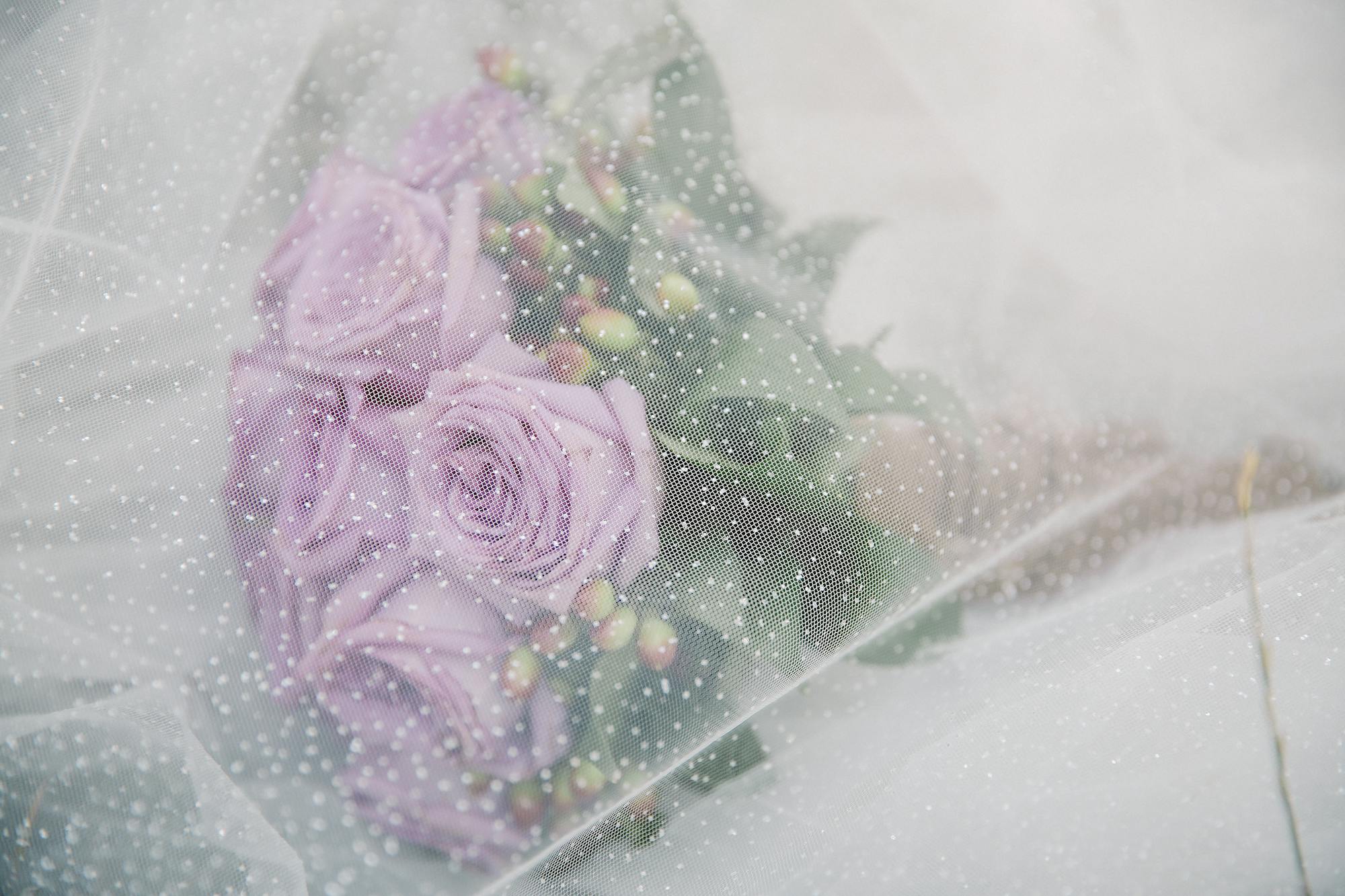 Bridal bouquet under a delicate veil