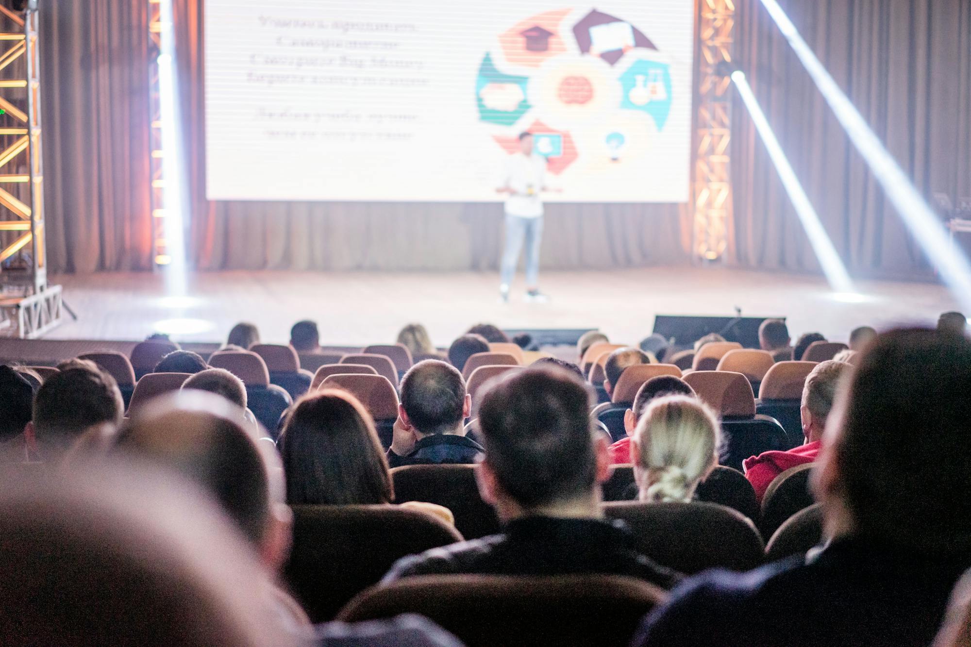 Audience watching a stage presentation with screen