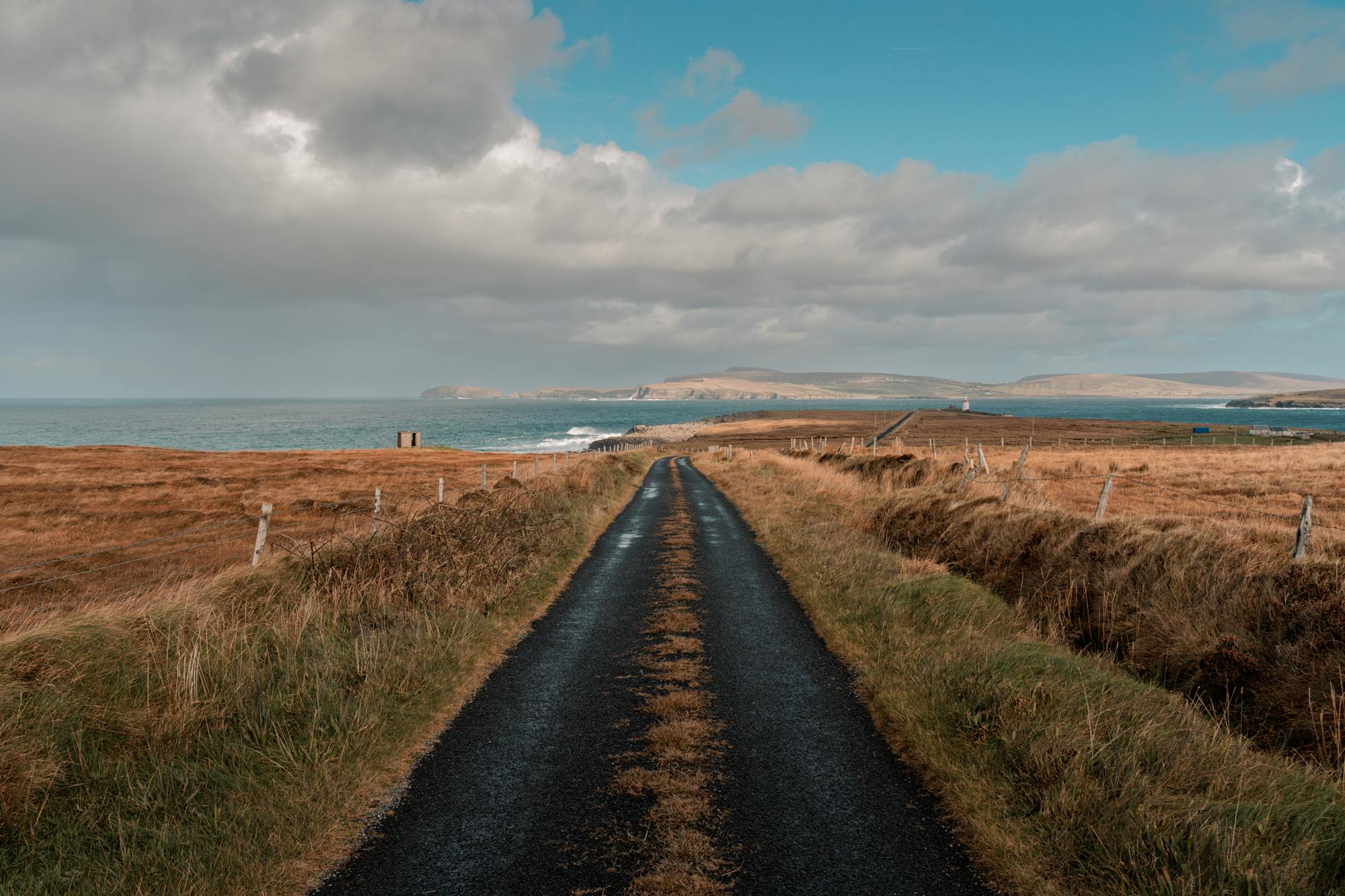 Coastal road winding through Irish countryside toward the sea