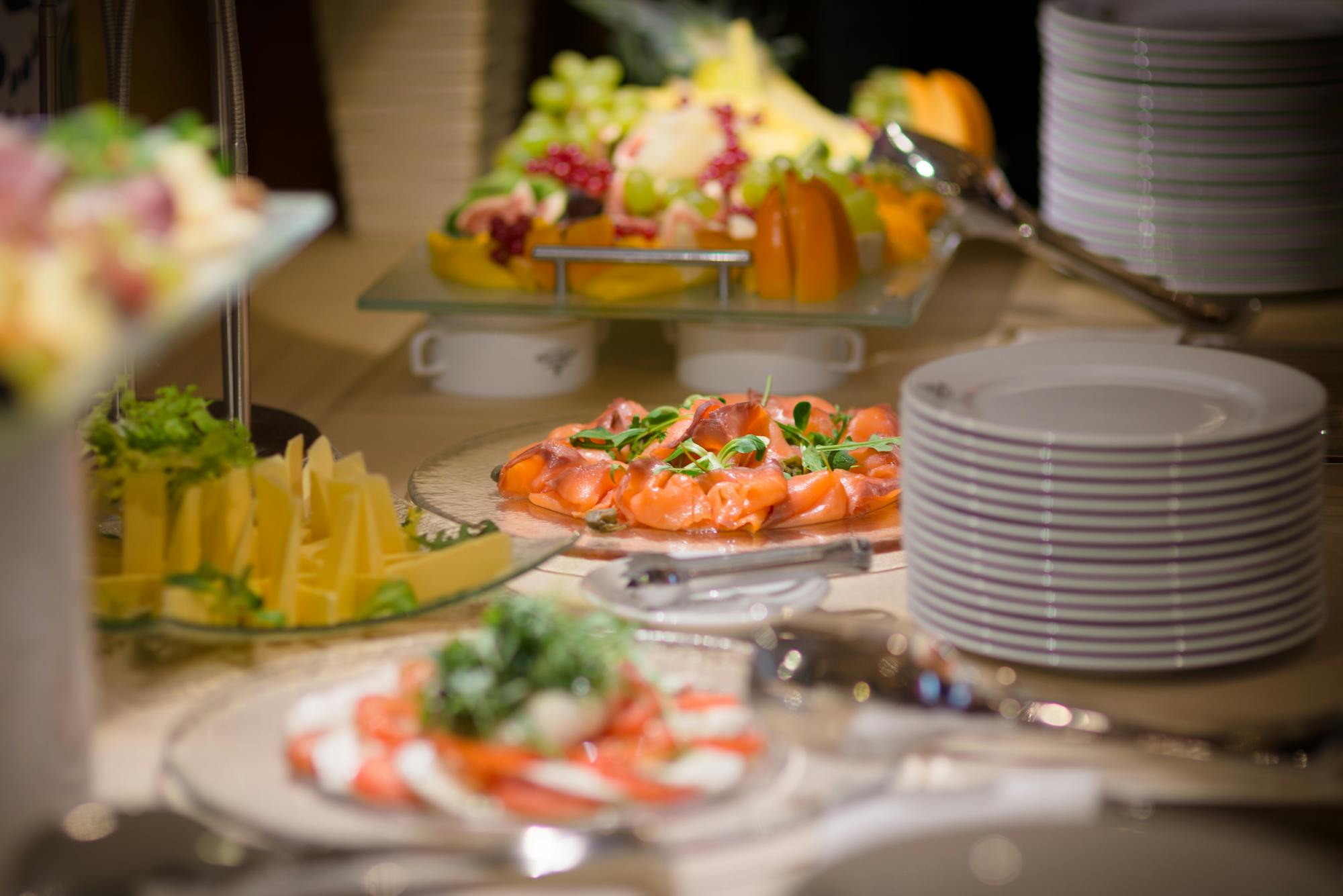 Elegant buffet display with salmon, fruit and cheese on tiered platters